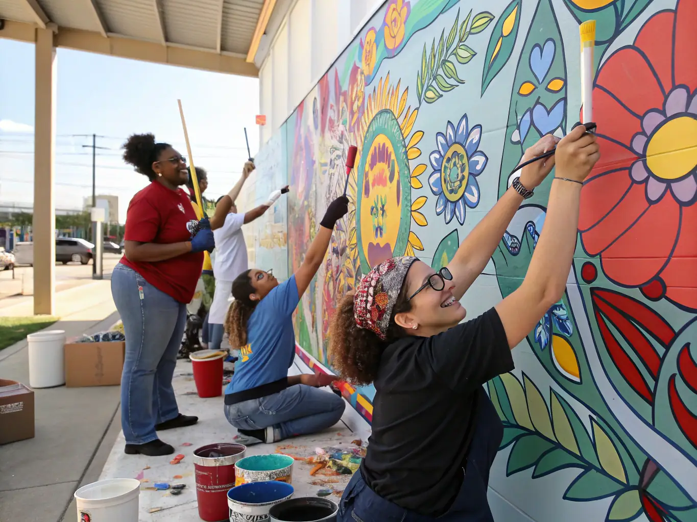 A vibrant image showcasing participants engaged in a multidisciplinary artistic project, such as a collaborative mural painting or a theatrical performance.